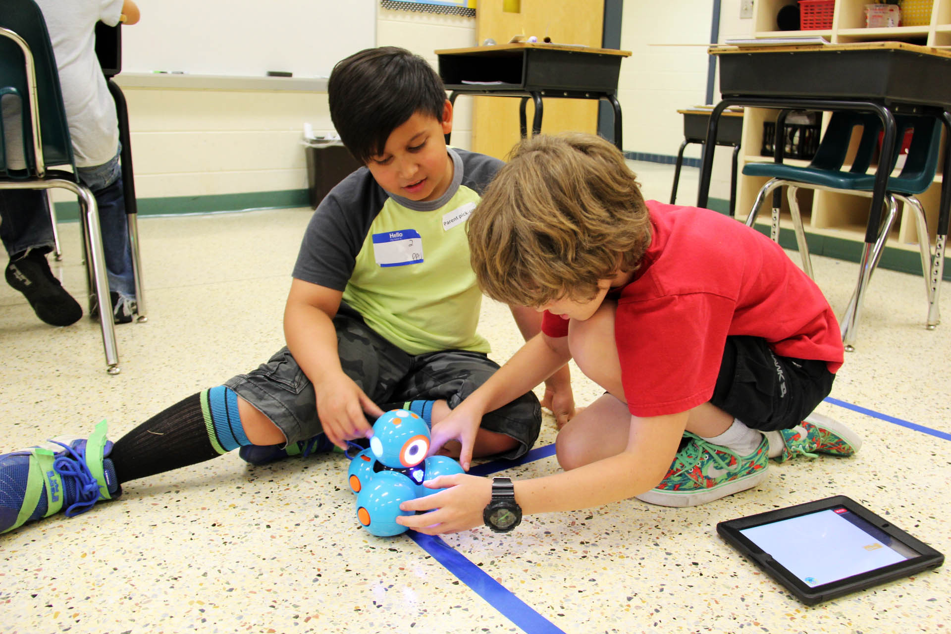 Kinder spielen mit Dash Roboter